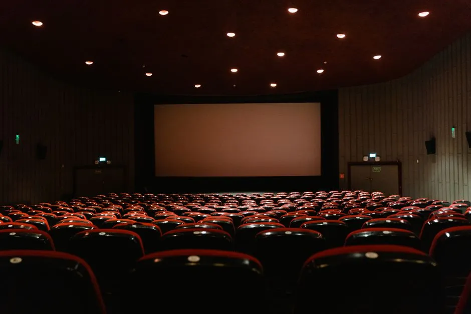 Empty movie theater auditorium with rows of seats facing a screen